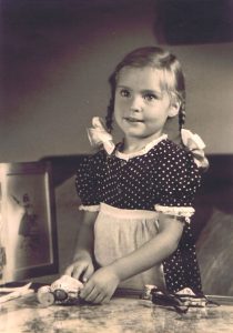 Sepia Halbtotale der jungen Autorin mit zwei Zöpfen und einem gepunktetem Kleid